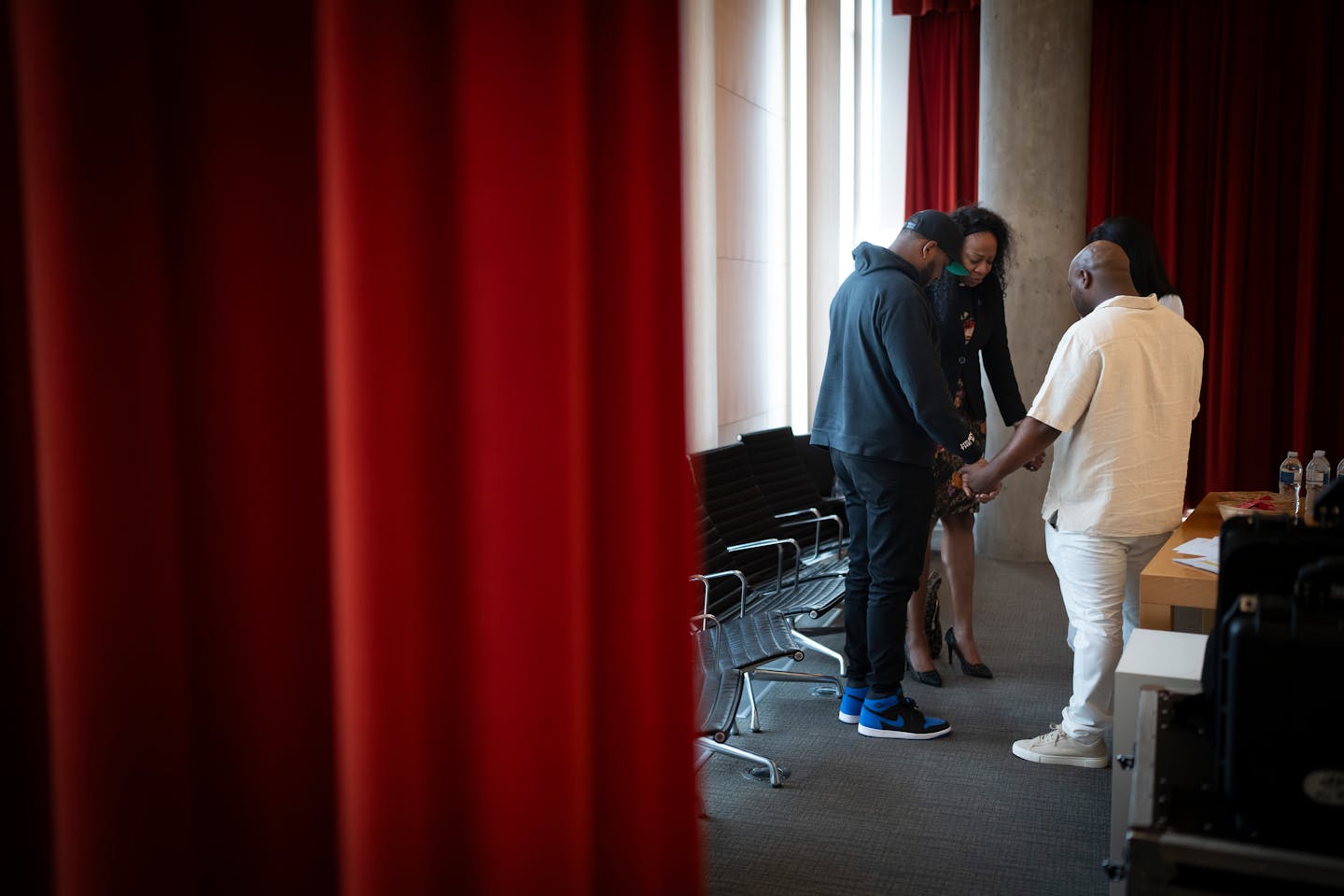Marvin Haynes holds hands in a circle with Terrance W. Moore, Rev. JaNaé Bates, and Aurin Chowdhury before they spoke on a book club panel sharing their experiences with the prison system in Minneapolis, Minn. on Thursday, May 16, 2024. 