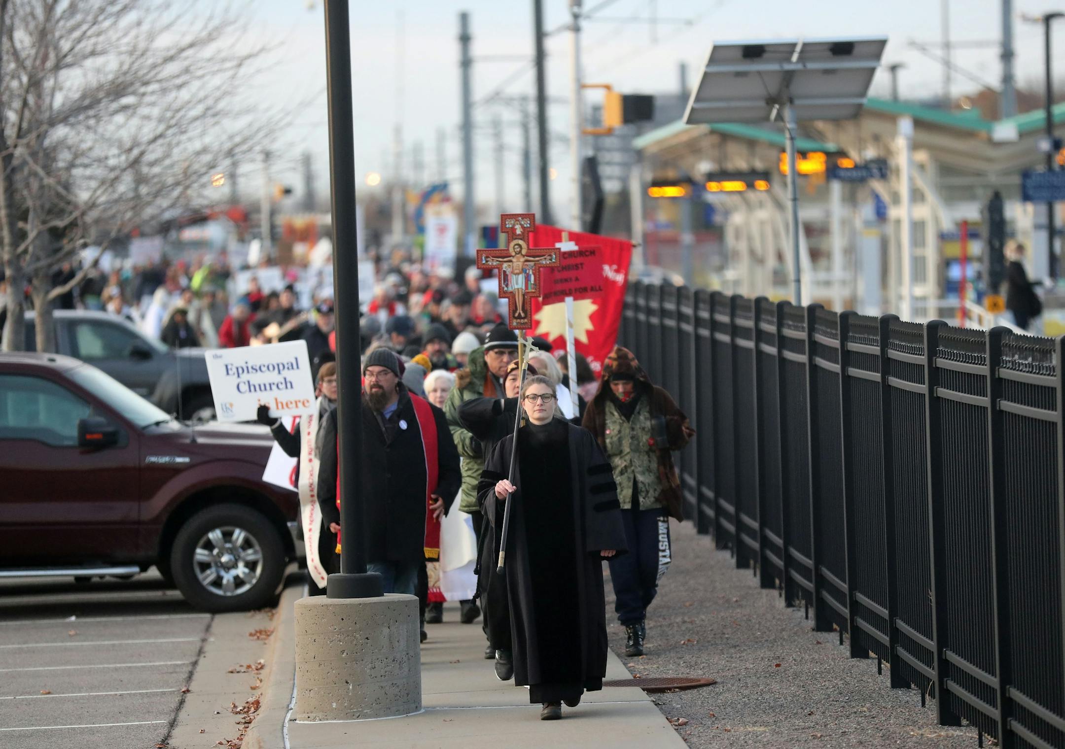 People process towards the Whipple Federal Building Tuesday, Oct. 29, 2019, in St. Paul, MN. Clergy and protestors gathered for a service and communion outside the Whipple Federal Building and to protest the naming of the building after the Episcopal bishop because deportations and other actions at the courthouse are in opposition to the beliefs of the Episcopal church, they stated.