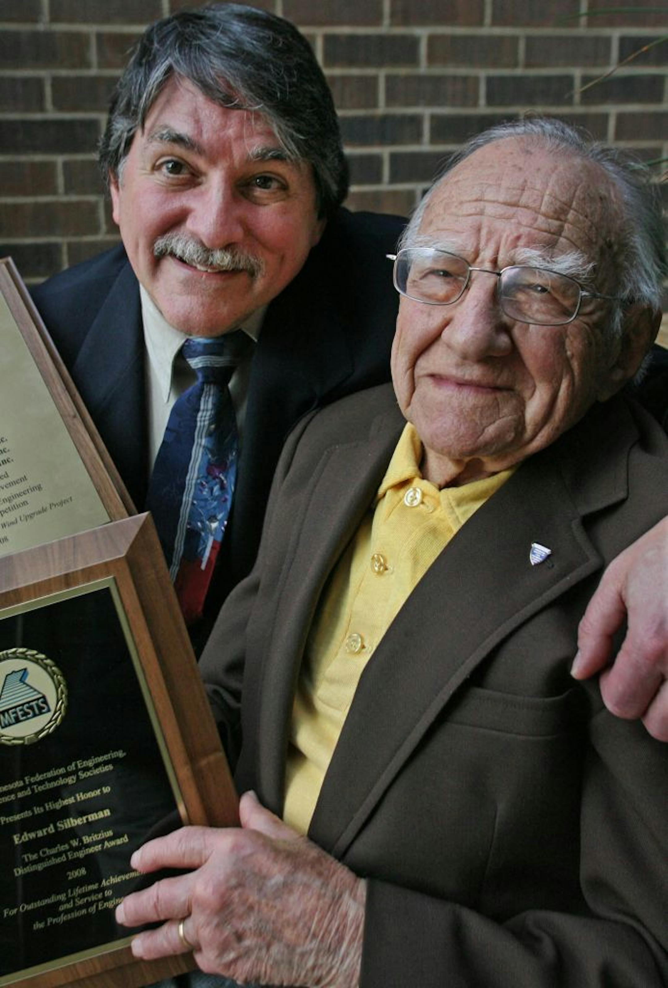 Sheldon Silberman, left and Edward Silberman with the awards bestowed upon them.