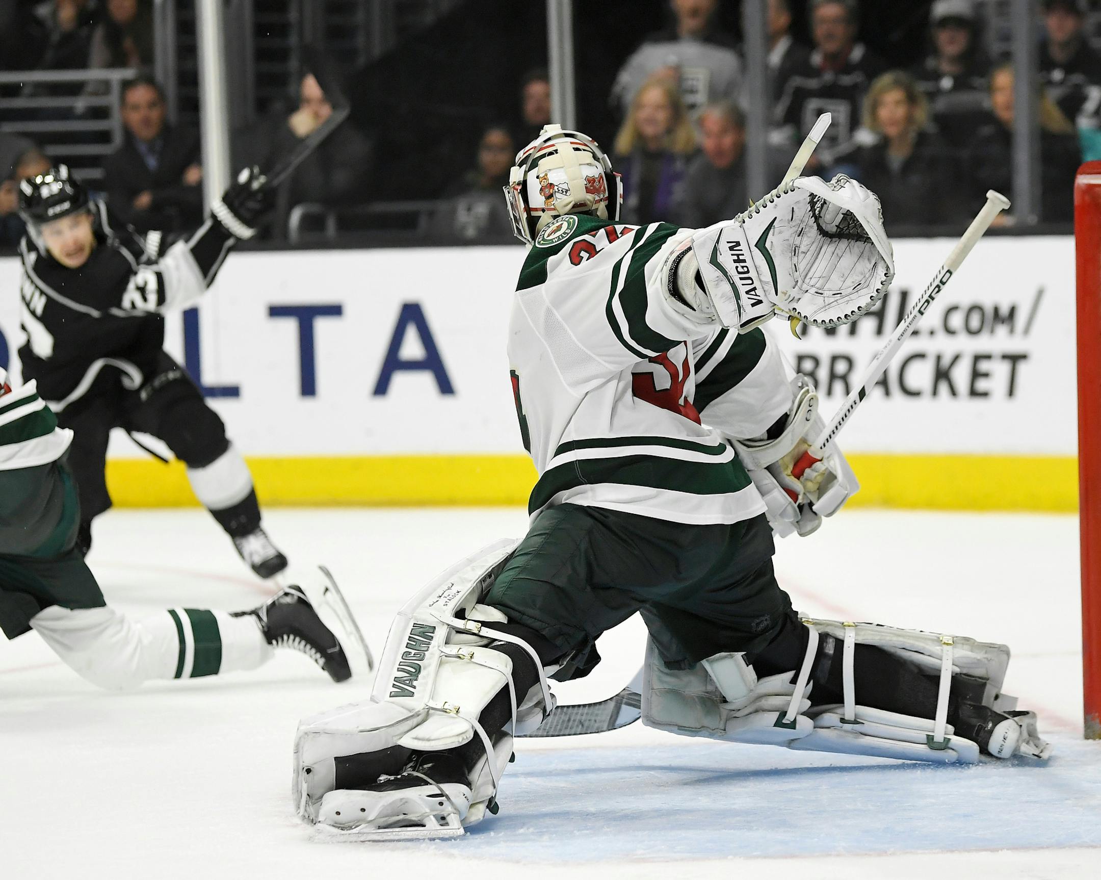 Los Angeles Kings right wing Dustin Brown, left, shoots and scores on Minnesota Wild goaltender Alex Stalock during overtime of an NHL hockey game Thursday, April 5, 2018, in Los Angeles. The Kings won 5-4. (AP Photo/Mark J. Terrill)