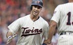 Minnesota Twins' Joe Mauer celebrates his home run with third base coach Gene Glynn against the Detroit Tigers in the first inning during a baseball g