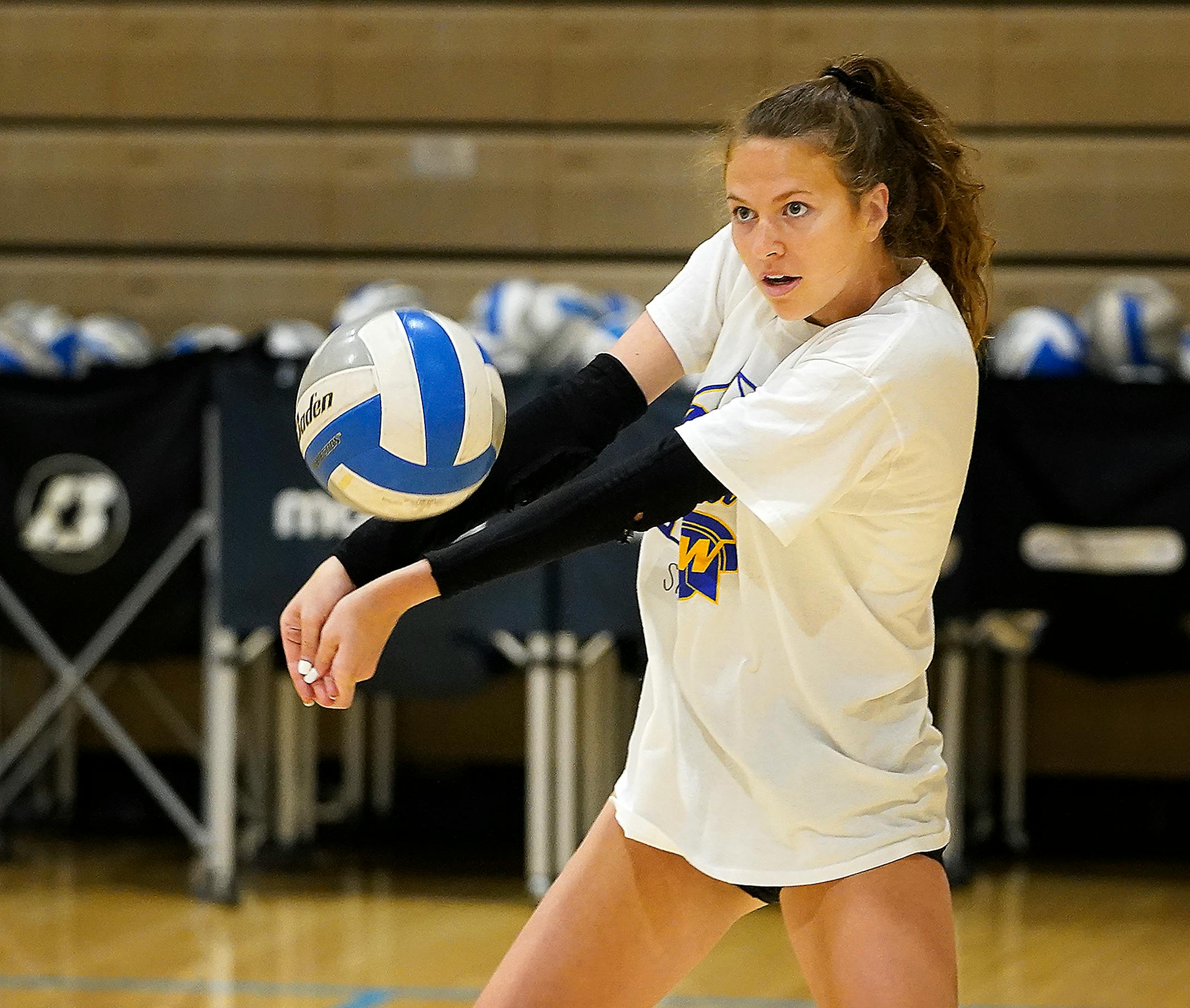 Wayzata High girls volleyball player Sophia Johnson bumps a shot during the first day of practice .