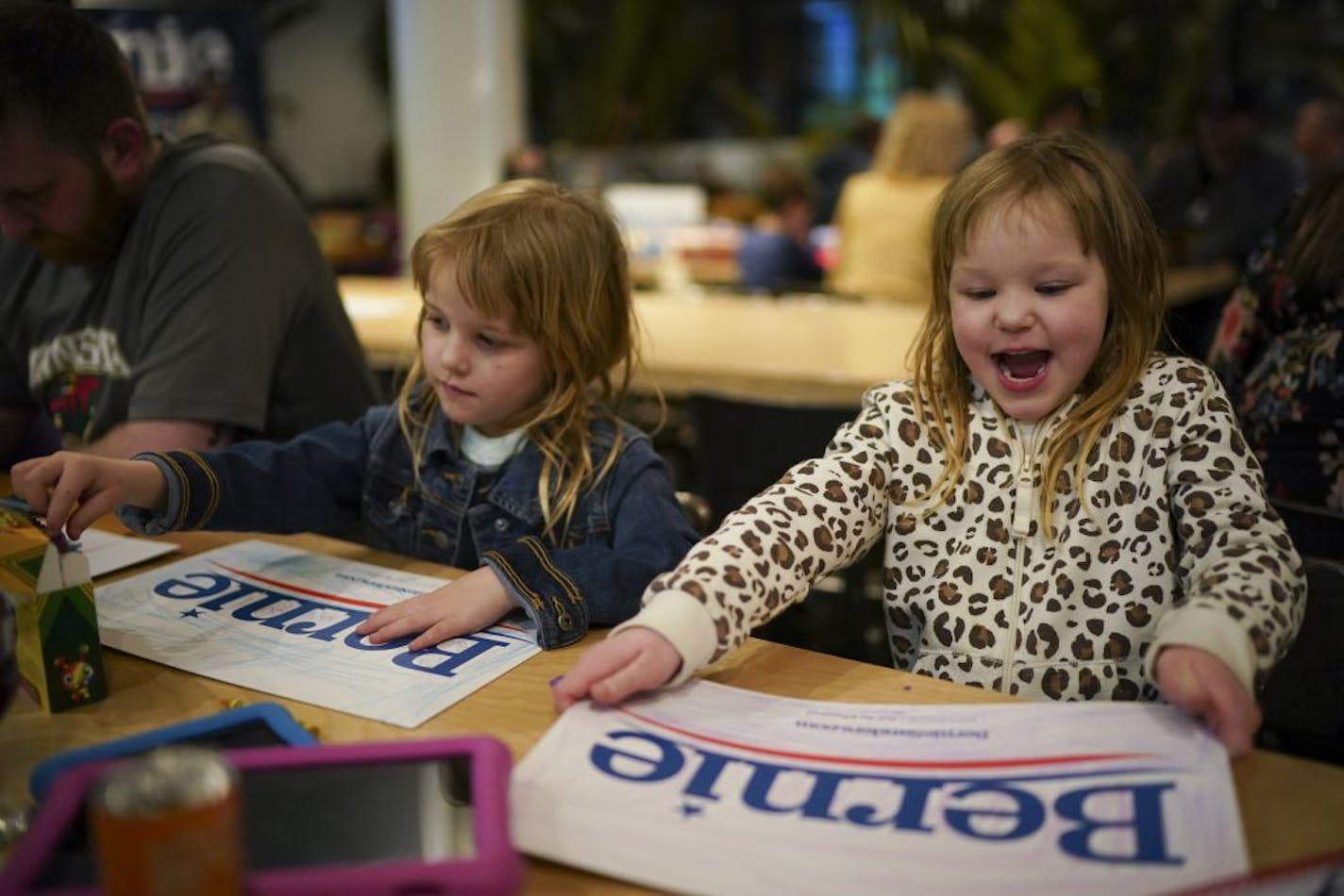 Annika Schroeder, left, and her twin sister, Sydney, 5, colored on Bernie Sanders campaign signs after eating dinner with their parents at BlackStack Brewing.