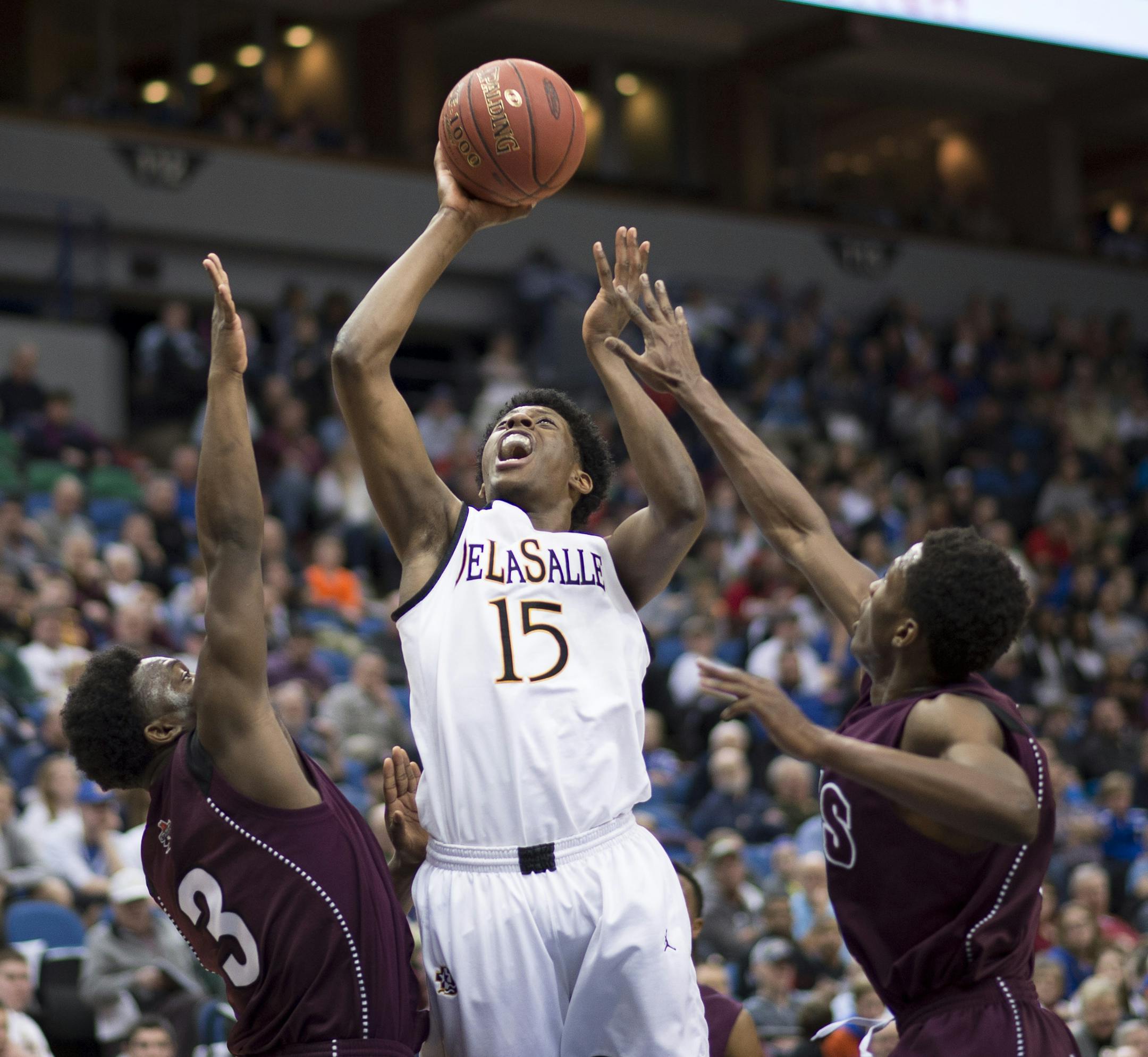 DeLaSalle forward Sacar Anim (15) gets through the defense of St. Paul Johnson guard Jalen Mobley (3) and forward Eric Elliott (24) to score in the first half. ] (Aaron Lavinsky | StarTribune) St. Paul Johnson takes on DeLaSalle in the Class 3A boys' basketball championship game on Saturday, March 14, 2014 at Target Center.