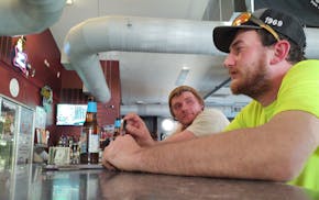 Best friends Cody Masog and Jeff Hall drink at a Parkers Prairie bar after a long work week. The two say they would vote for President Trump if he run