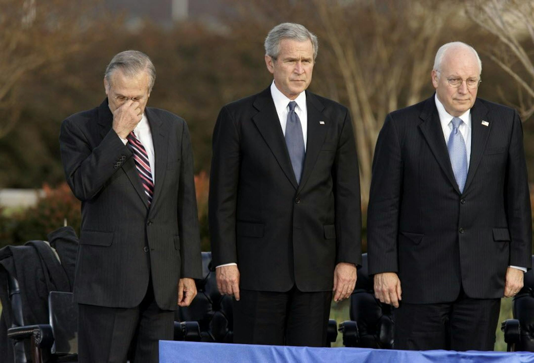 FILE - In this Friday, Dec. 15, 2006, file photo, Secretary of Defense Donald Rumsfeld, left, pauses as President George W. Bush, and Vice President Dick Cheney participate in Rumsfeld's farewell ceremony at the Pentagon in Washington. Former President George H.W. Bush is publicly criticizing for the first time key members of his son's administration. A biography of the nation's 41st president to be published in November, 2015, contains his sharply critical assessments of Cheney and Rumsfeld.