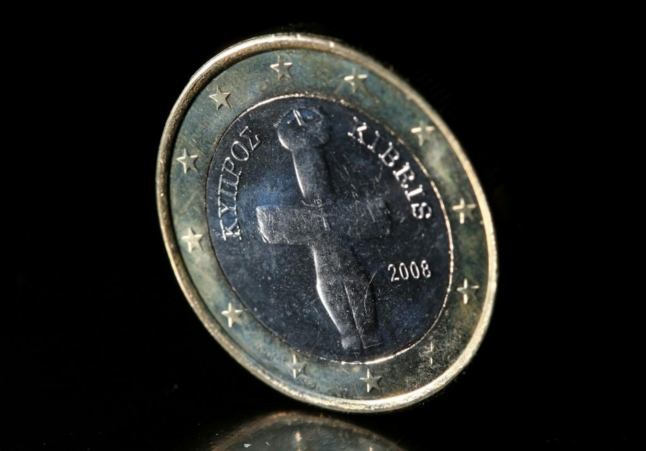 A Cypriot euro coin is photographed in Cologne, Germany, Monday, March 18, 2013. A plan to seize up to 10 percent of people's savings in the small mediterranean island country of Cyprus unsettled markets Monday and raised questions about whether households� trust in banks would be permanently shaken. A weekend agreement between Cyprus and its European partners called for the government to raid bank accounts as part of a euro 15.8 billion (US$ 20.4 billion) financial bailout, the first time in th