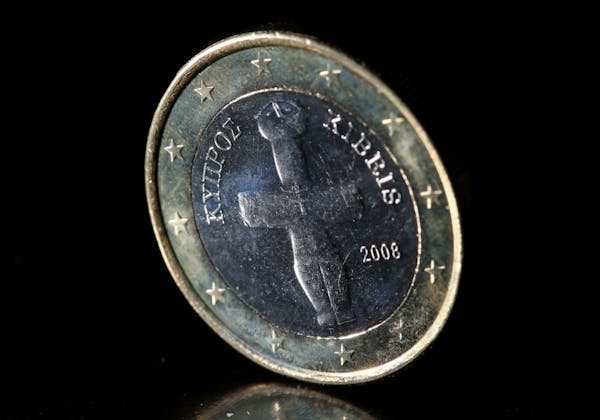 A Cypriot euro coin is photographed in Cologne, Germany, Monday, March 18, 2013. A plan to seize up to 10 percent of people's savings in the small med