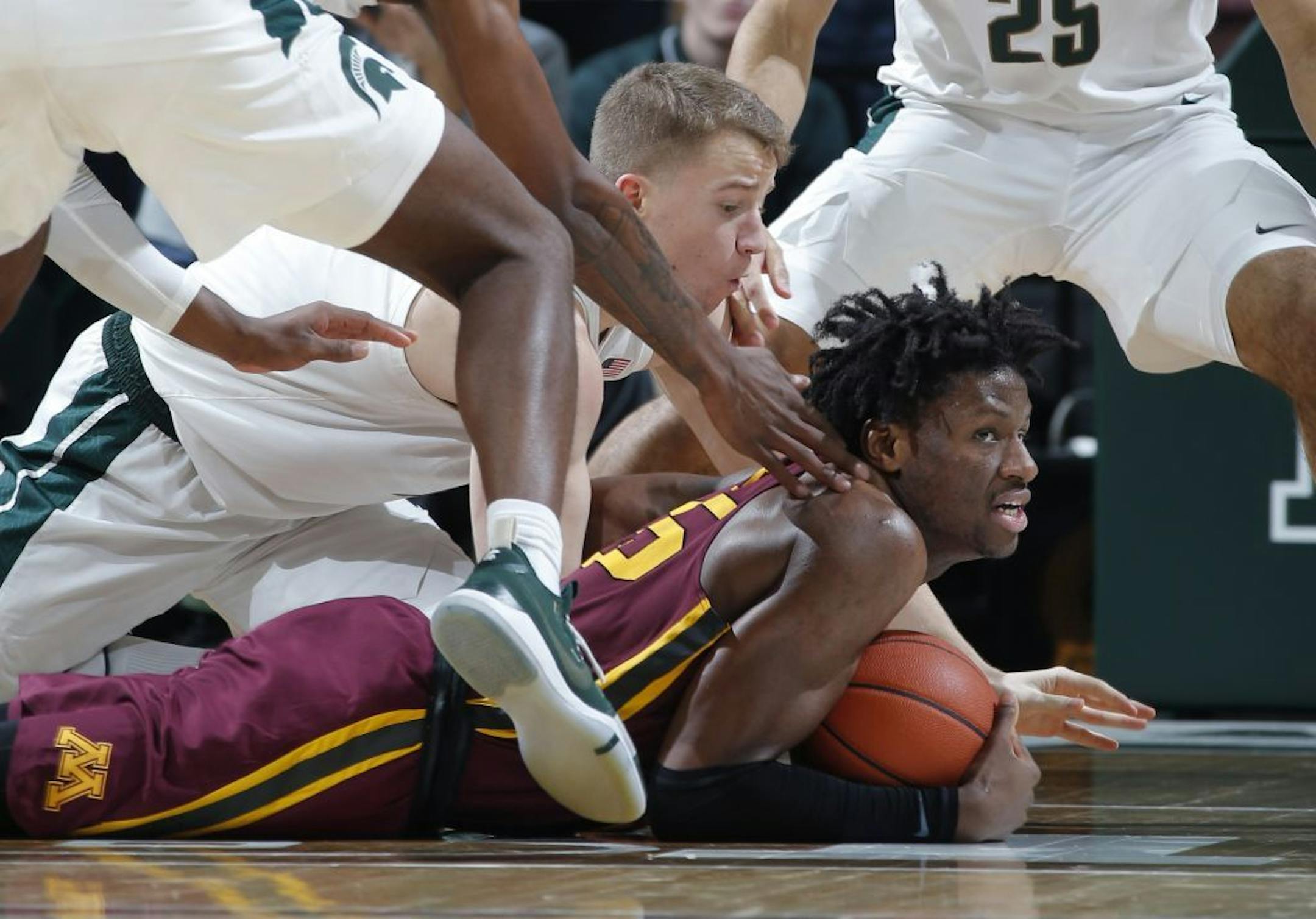 Minnesota's Daniel Oturu, right, and Michigan State's Thomas Kithier scramble for the ball