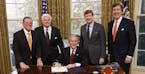 President George W. Bush, joined by Republican Senator Pete V. Domenici of New Mexico, Democratic Senator Edward M. Kennedy of Massachusetts, U.S. Rep
