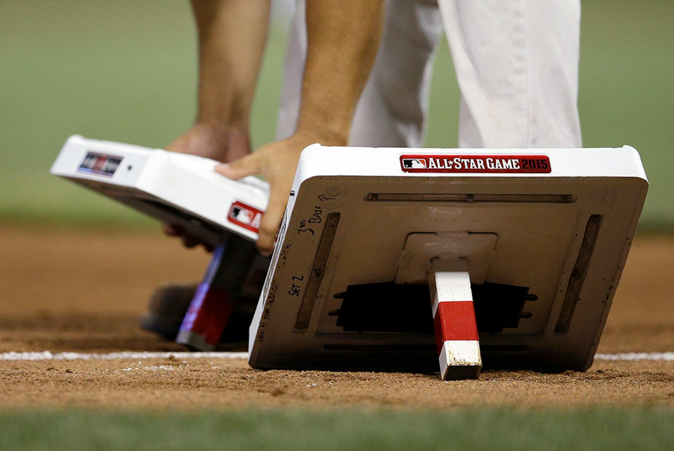 A worker changes bases at start of fifth inning of the MLB All-Star baseball game, Tuesday, July 14, 2015, in Cincinnati.