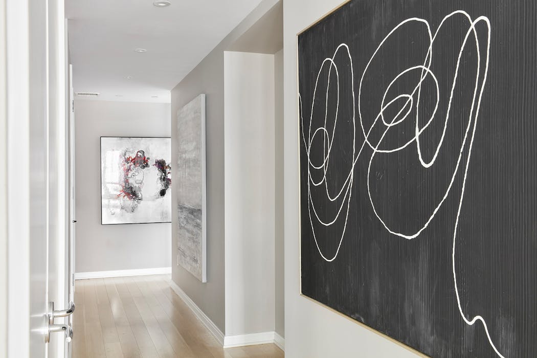 Black-and-white artwork adds a bold, modern edge to a hallway. 