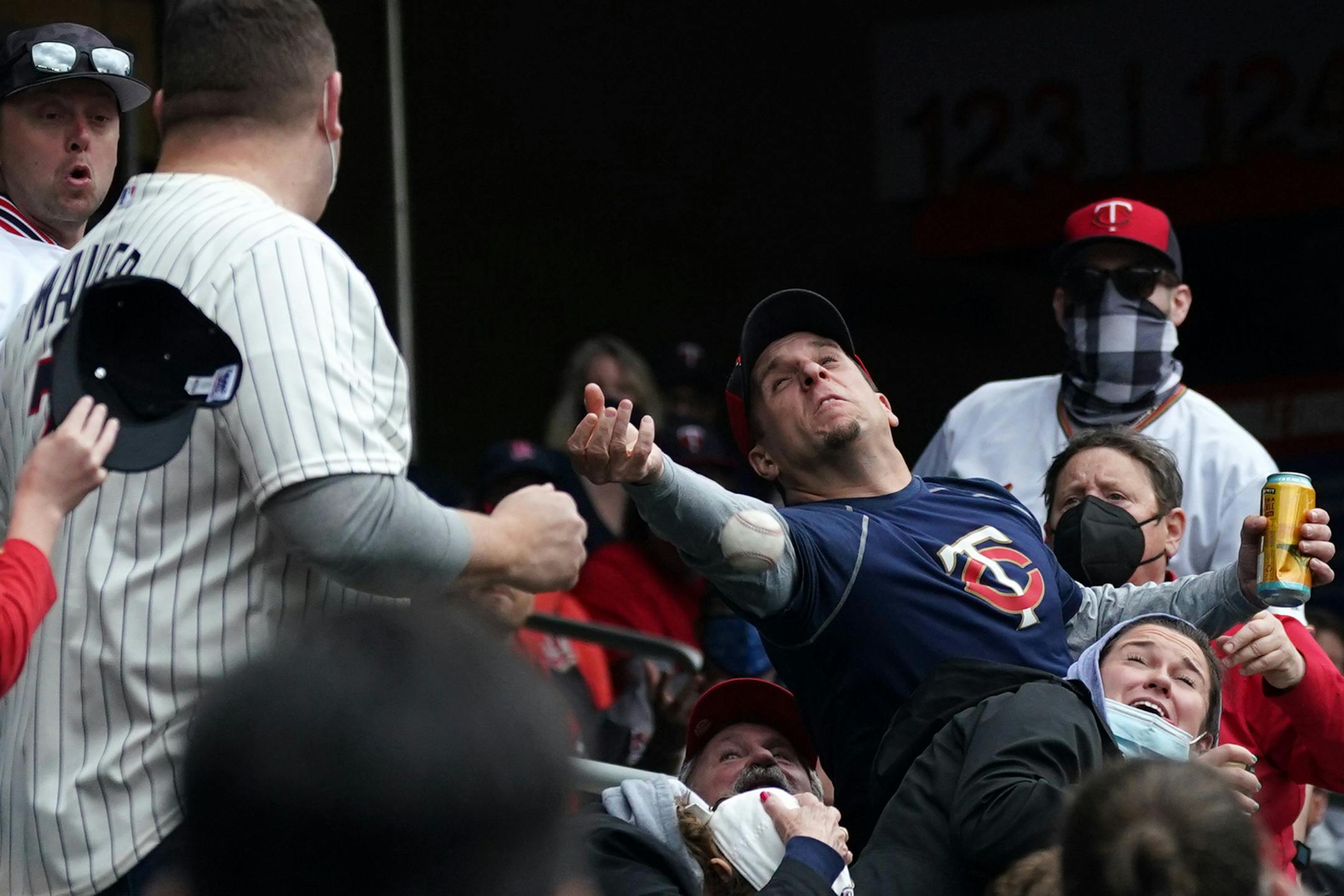 A Minnesota Twins fan reaches unsuccessfully for a foul ball in the third inning during the home opener against the Seattle Mariners at Target Field in Minneapolis on Thursday, April 8, 2021. (Anthony Souffle/Minneapolis Star Tribune/TNS) ORG XMIT: 13253797W