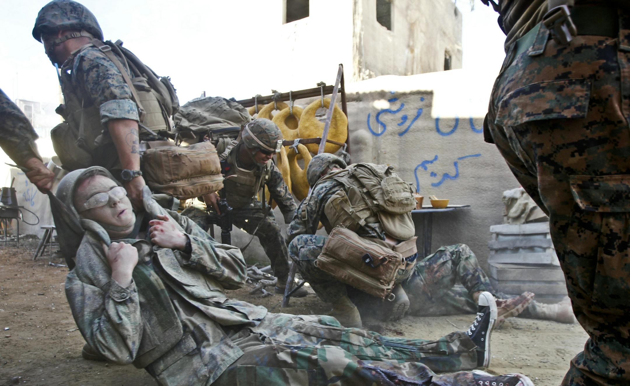 In this Dec. 10, 2013, photo, a U.S. Navy corpsman pulls an actor to safety during a training mission at Strategic Operations where "reality based training" is used while working with U.S. military personnel in San Diego. (AP Photo/Lenny Ignelzi)