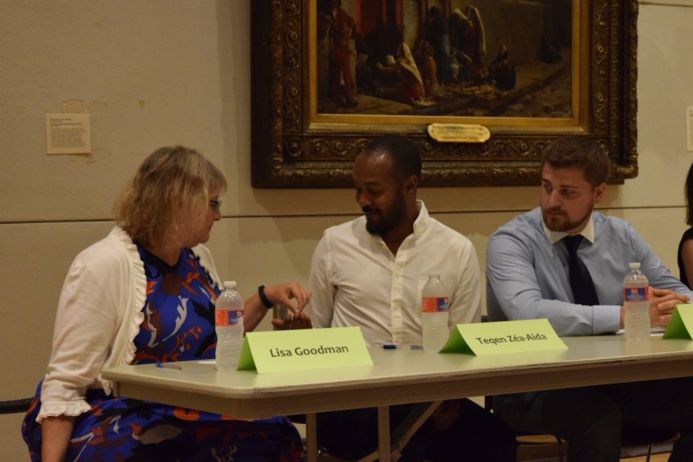 Minneapolis City Council Member Lisa Goodman handed her chewing gum to Teqen Zea-Aida, a challenger for the Seventh Ward council seat, at a candidate forum Tuesday.