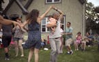 A crowd of friends, including Maria Schwedhelm and Sandro Rios, holding their son, Ilan, danced Afro Cuban style on Stephanie Owen's front yard on 28t