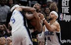 Cavaliers forward Evan Mobley, center, fights for control of the ball with Magic forward Paolo Banchero (5) and guard Jalen Suggs (4) in the second ha