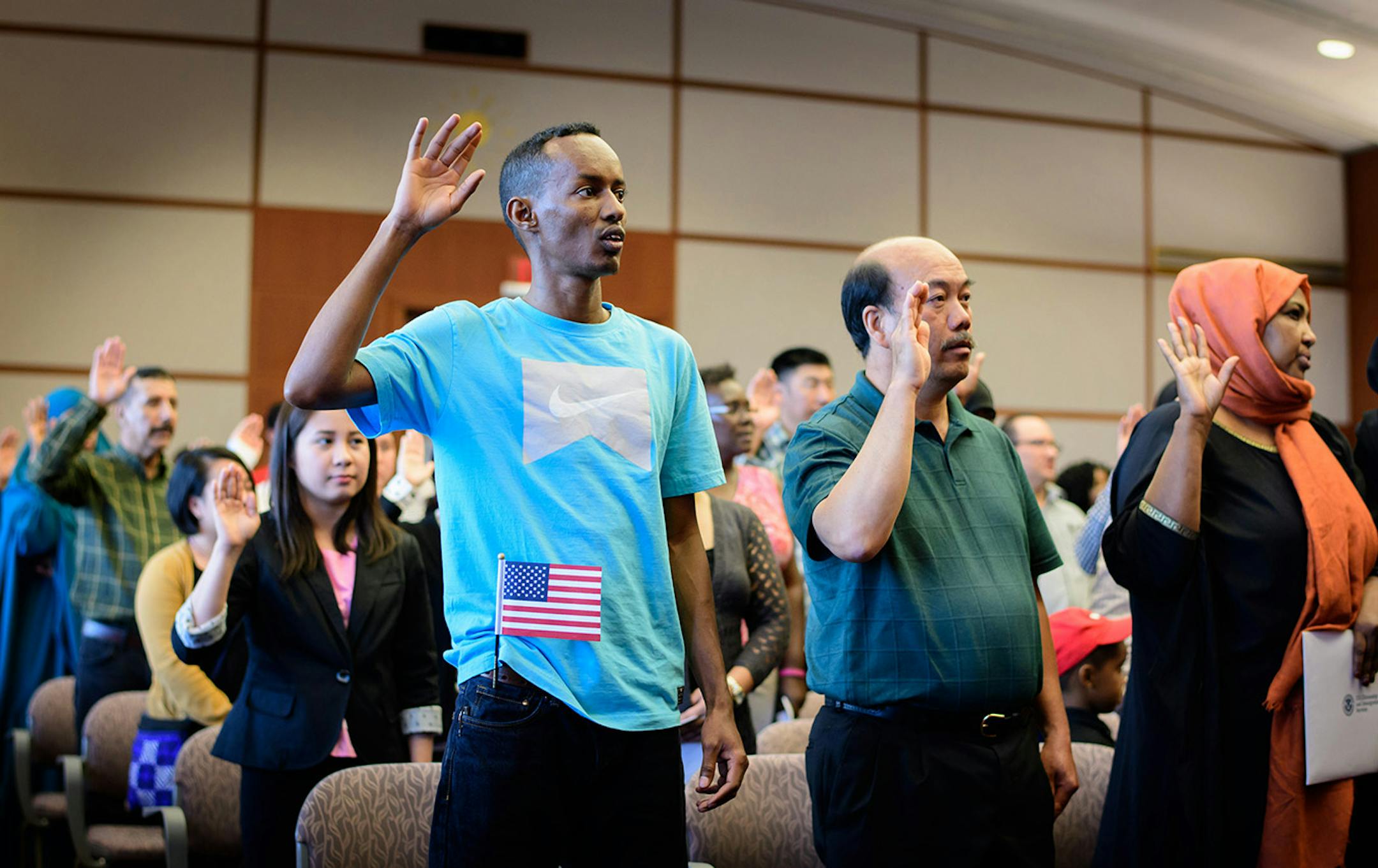 Farah Jama from Somalia, Wa Fong Lor of Laos, and Faduma Mahamoud of Somalia raised their hands to take the Oath of Allegiance. They were among the 55 people from 22 countries who became U.S. citizens.