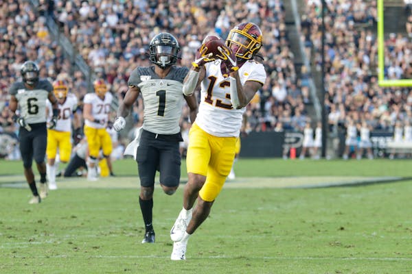 Gophers wide receiver Rashod Bateman makes a catch in front of Purdue cornerback Dedrick Mackey on his way to a touchdown during the second half