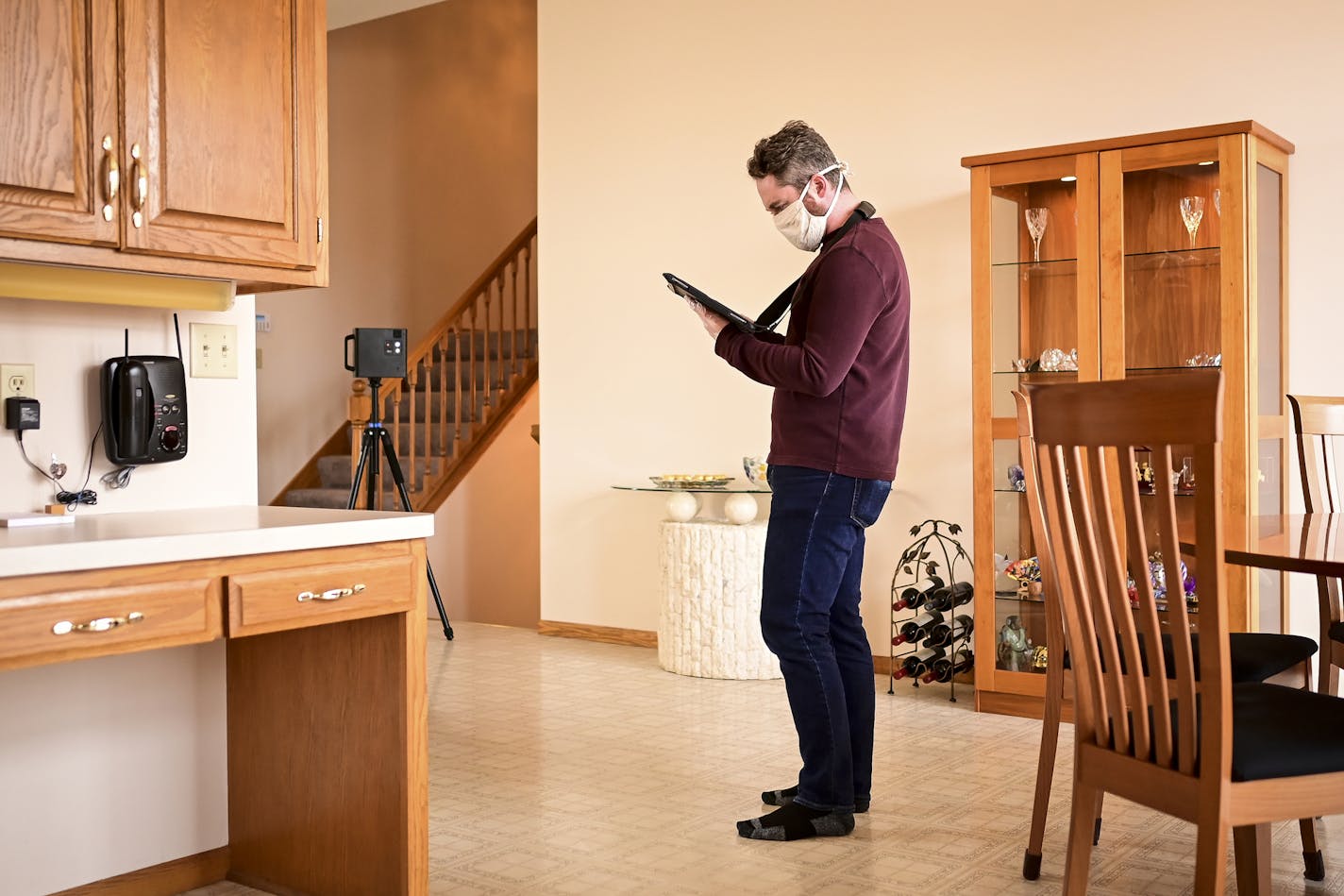 Photographer Justin Sorensen donned personal protective equipment as he used a 3D camera and an iPad to create a virtual tour of a Lakeville home which will be listed on the market soon.