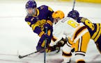Minnesota State forward Cade Borchardt, back left, passes the puck as forward Nathan Smith, back right, tries to block Minnesota defenseman Mike Koste