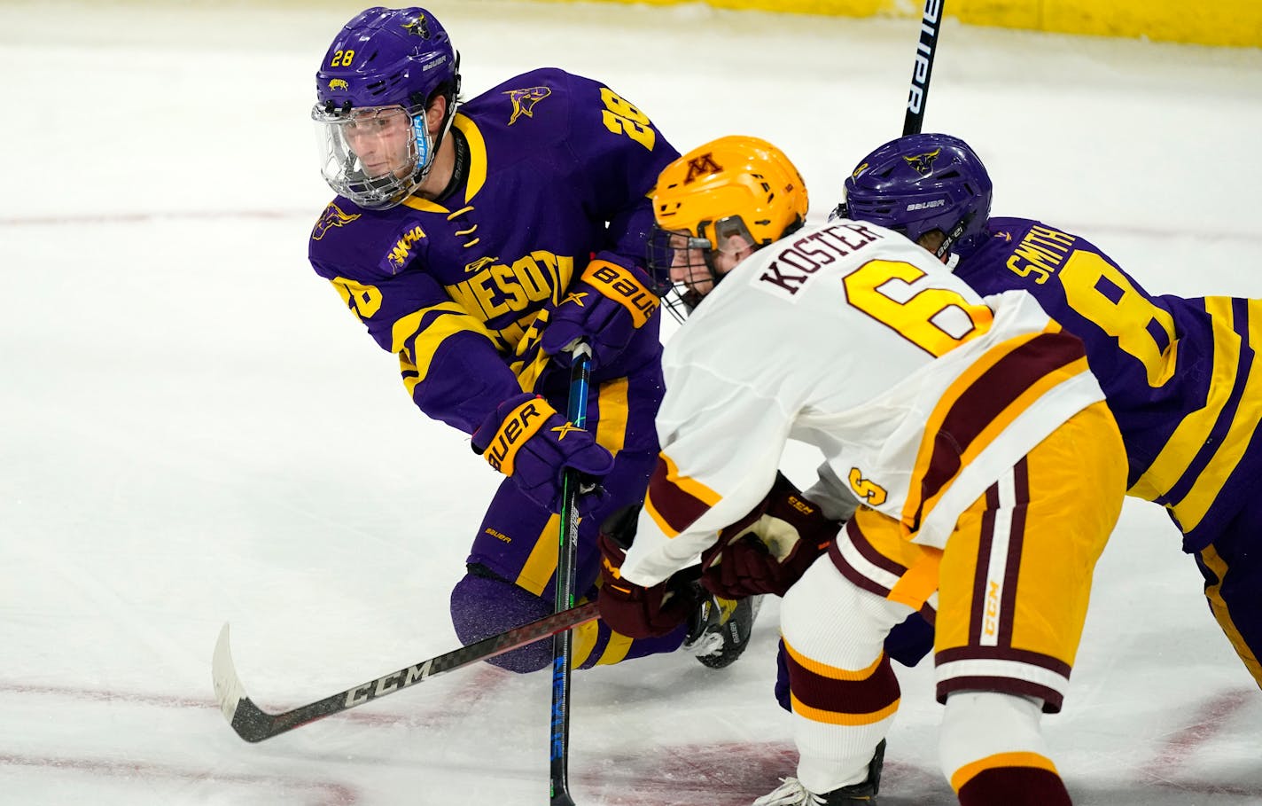 Minnesota State forward Cade Borchardt, back left, passes the puck as forward Nathan Smith, back right, tries to block Minnesota defenseman Mike Koster in the first period of an NCAA College Hockey Regional Final, Sunday, March 28, 2021, in Loveland, Colo. (AP Photo/David Zalubowski)