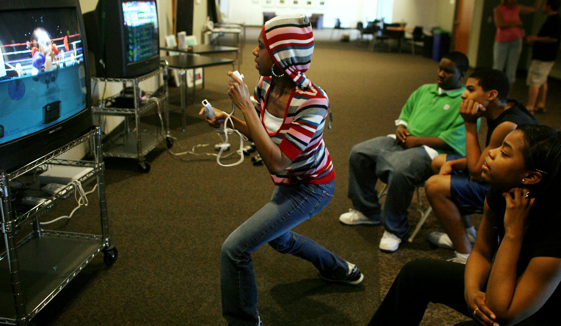 Champlin Park High School students, left to right, Keenan Hooper, McDaniel Doe, and Naomi Davis watched as classmate Veronica O'Neal tried her hand at boxing on a Wii game. The students gather after school at a teen center set up at Grace Fellowship Church in Champlin.
