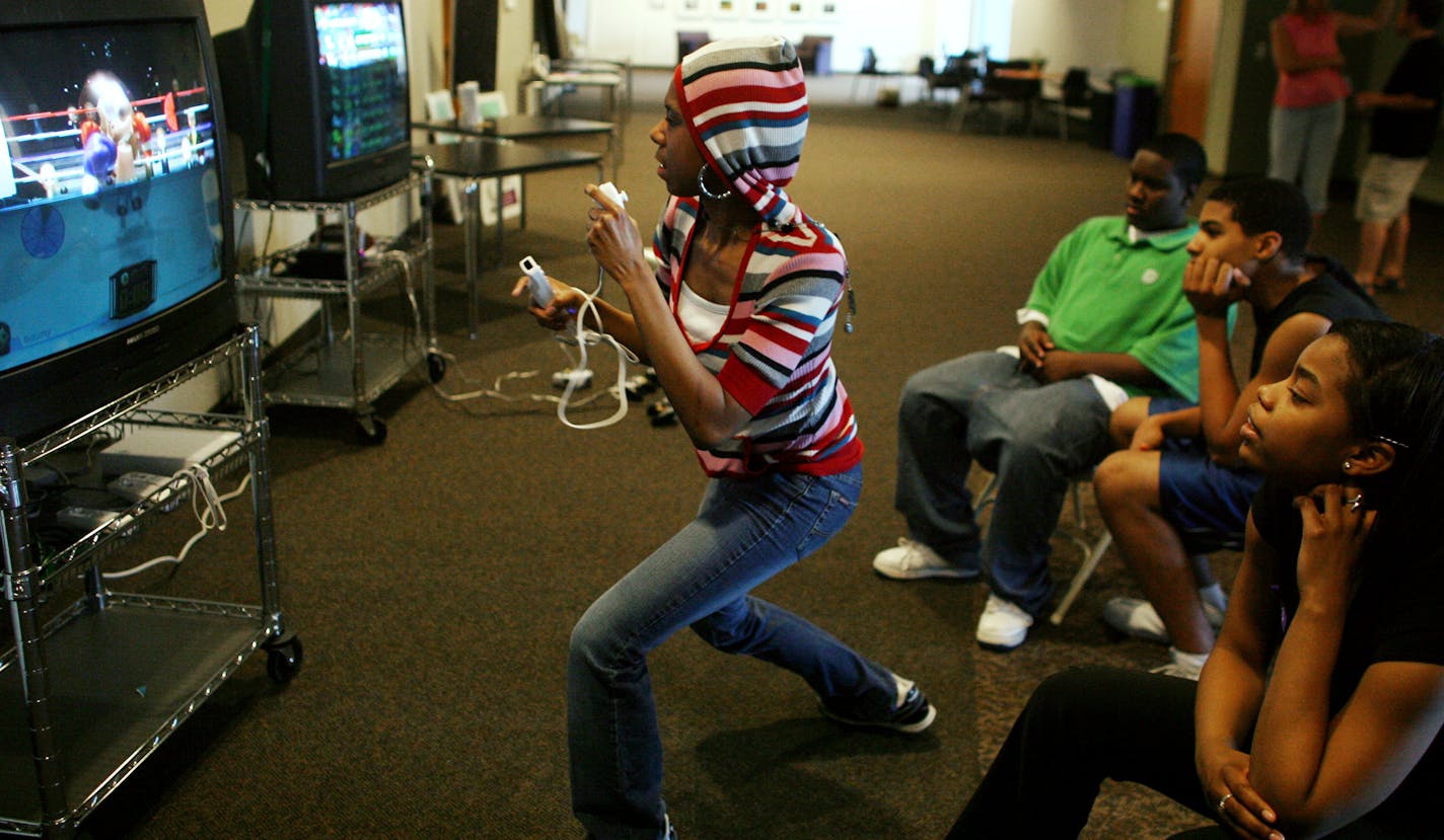 Champlin Park High School students, left to right, Keenan Hooper, McDaniel Doe, and Naomi Davis watched as classmate Veronica O'Neal tried her hand at boxing on a Wii game. The students gather after school at a teen center set up at Grace Fellowship Church in Champlin.