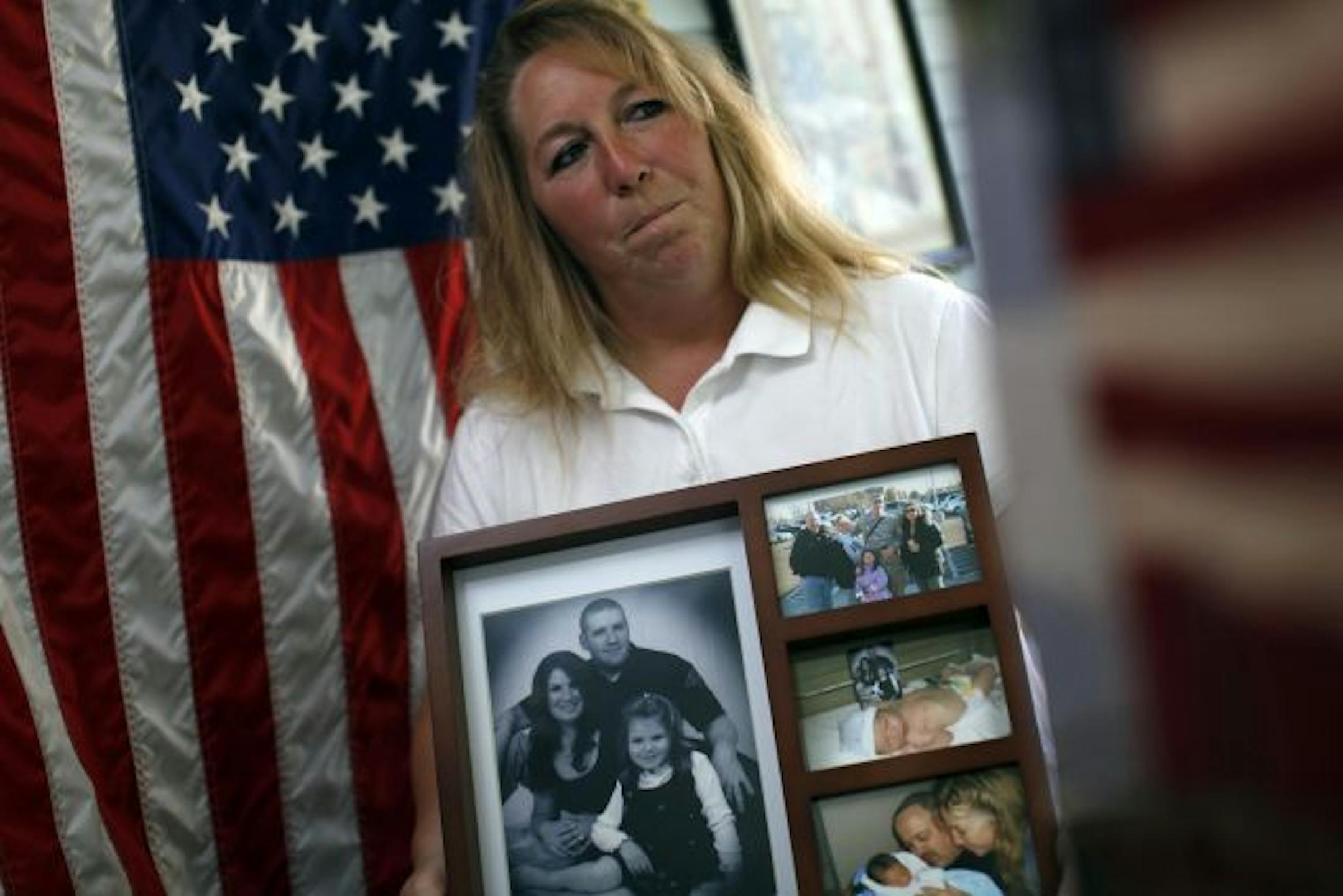 Teresa Ash of St. Paul holds a collection of photographs of her son�s Jake England with his wife Abby their daughter Madelyn and son Collin.