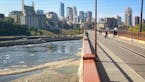 People wandered the Mississippi River bottom Monday afternoon below the Stone Arch Bridge as the Army Corps of Engineers lowered the river to allow in
