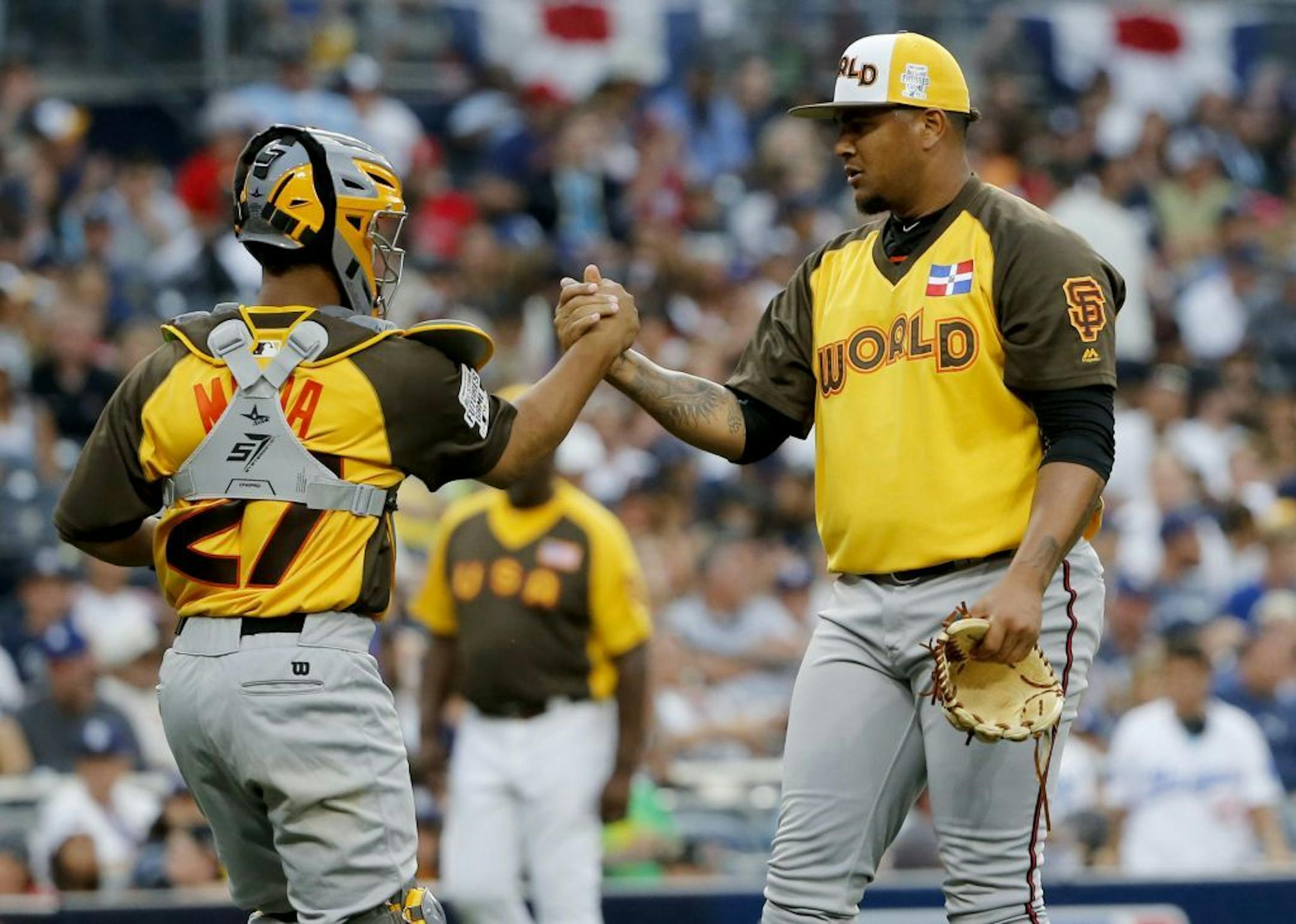 World Team pitcher Adalberto Mejia, of the San Francisco Giants, and catcher Francisco Mejia (27) celebrate their 11-3 win against the U.S. Team after the All-Star Futures baseball game, Sunday, July 10, 2016, in San Diego.