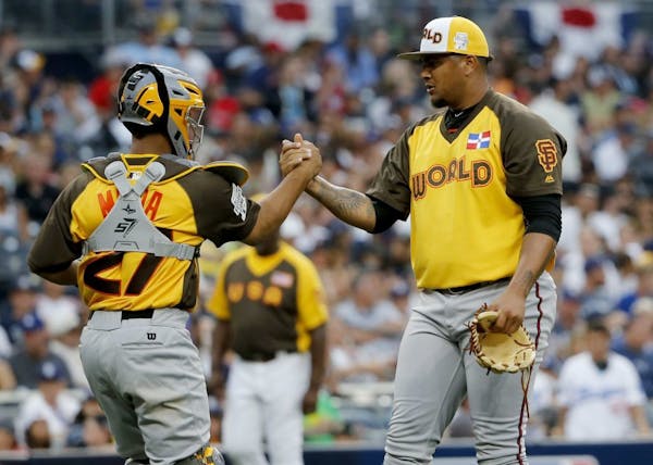 World Team pitcher Adalberto Mejia, of the San Francisco Giants, and catcher Francisco Mejia (27) celebrate their 11-3 win against the U.S. Team after