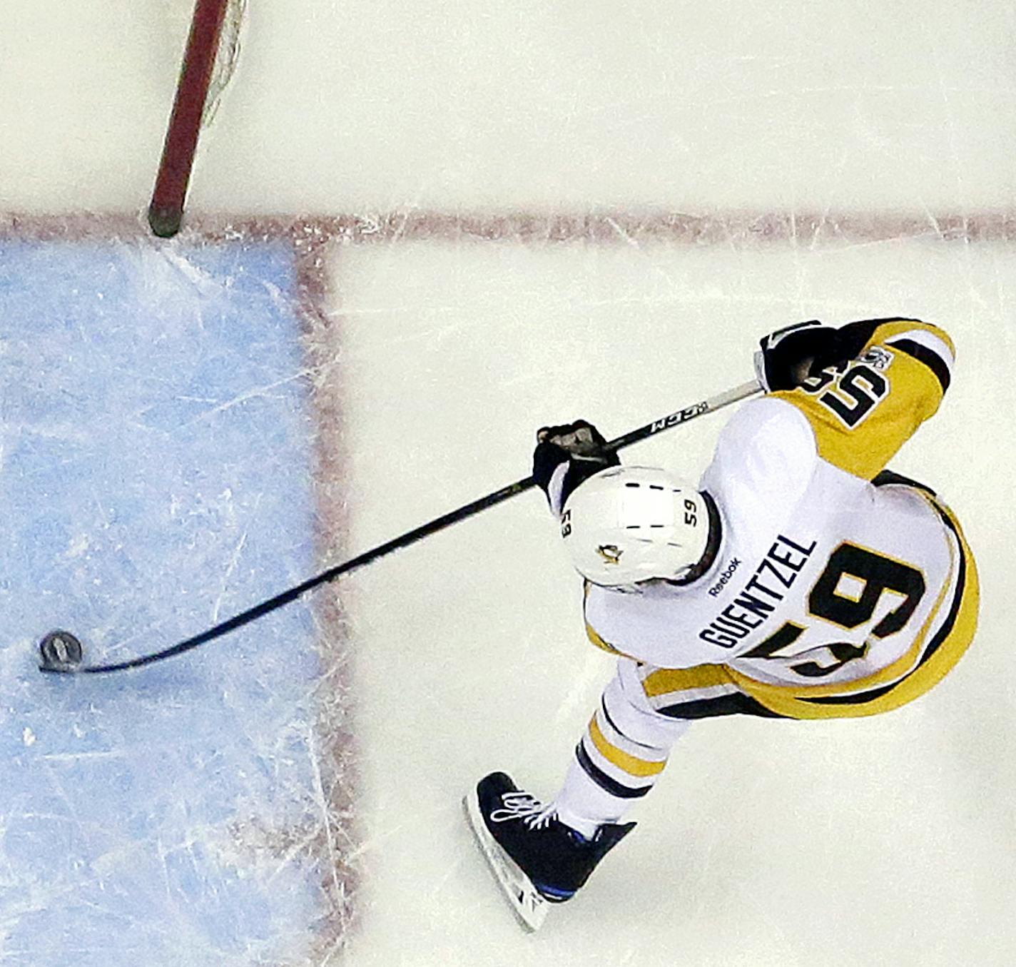 Pittsburgh Penguins center Jake Guentzel, right, prepares to score a goal on New Jersey Devils goalie Cory Schneider, left, as defenseman Michael Kapla tries to help defend during the first period of an NHL hockey game, Thursday, April 6, 2017, in Newark, N.J. The Penguins won 7-4. (AP Photo/Julio Cortez)