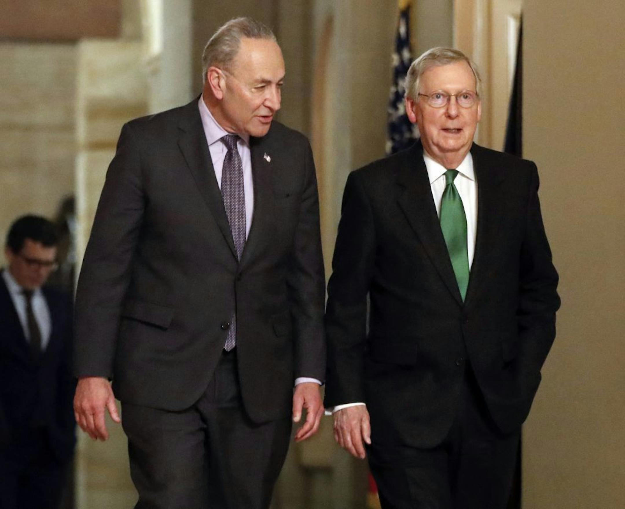 The leaders of the U.S. Senate: Democrat Chuck Schumer of New York, left, and Republican Mitch McConnell of Kentucky walked Wednesday after collaborating on an agreement in the Senate on a two-year, almost $400 billion budget deal.
