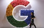FILE - In this Monday, Nov. 5, 2018 file photo, a woman walks past the logo for Google at the China International Import Expo in Shanghai. By U.S. sta