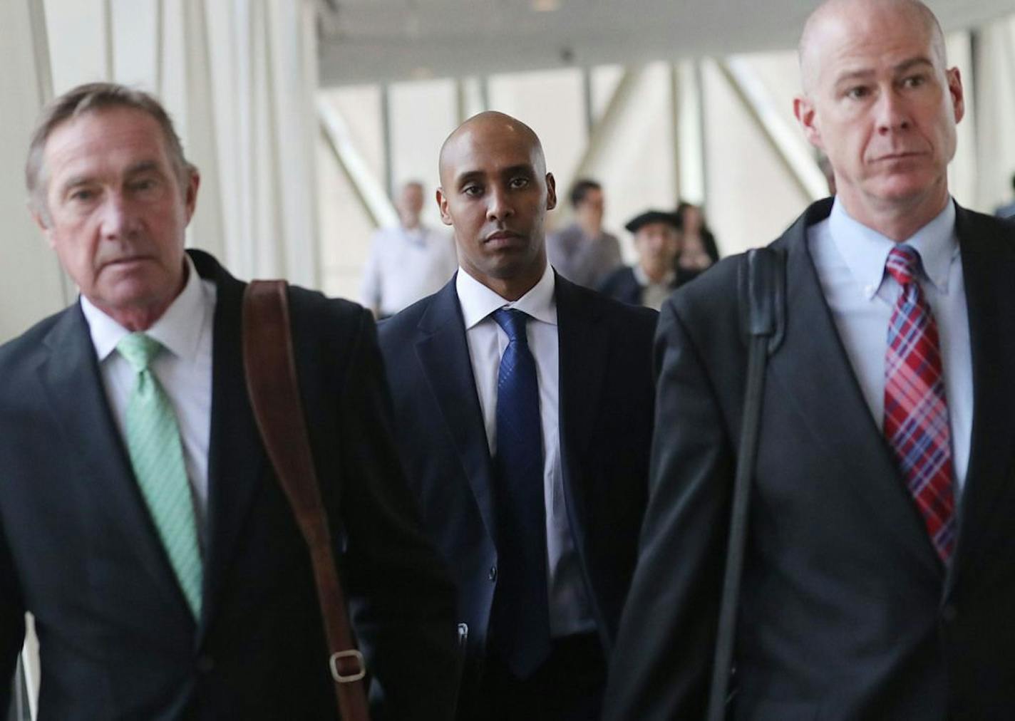 Former Minneapolis police officer Mohamed Noor, middle, is flanked by his attorneys Peter Wold, left, and Thomas Plunkett, right, as he breaks for lunch Tuesday, April 9, 2019, at the Hennepin County Government Center in Minneapolis, MN.