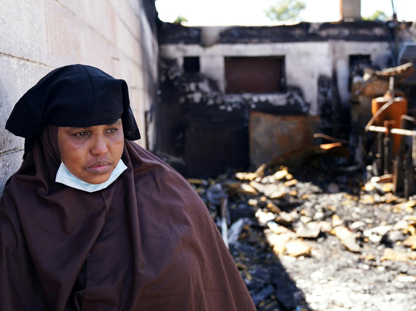 Kaltuma Hassan, who lost the Bismillah Grocery & Coffee shop during the riots, welled with tears while she revisited the scene Thursday. ] ANTHONY SOUFFLE • anthony.souffle@startribune.com Kaltuma Hassan, who lost the Bismillah Grocery & Coffee shop during the riots, revisited the scene Thursday, July 23, 2020 in south Minneapolis. Hassan was robbed of $7,000 and hit on the head with a gun while trying to defend her shop. She blames the city for not protecting her or her property, and wants the