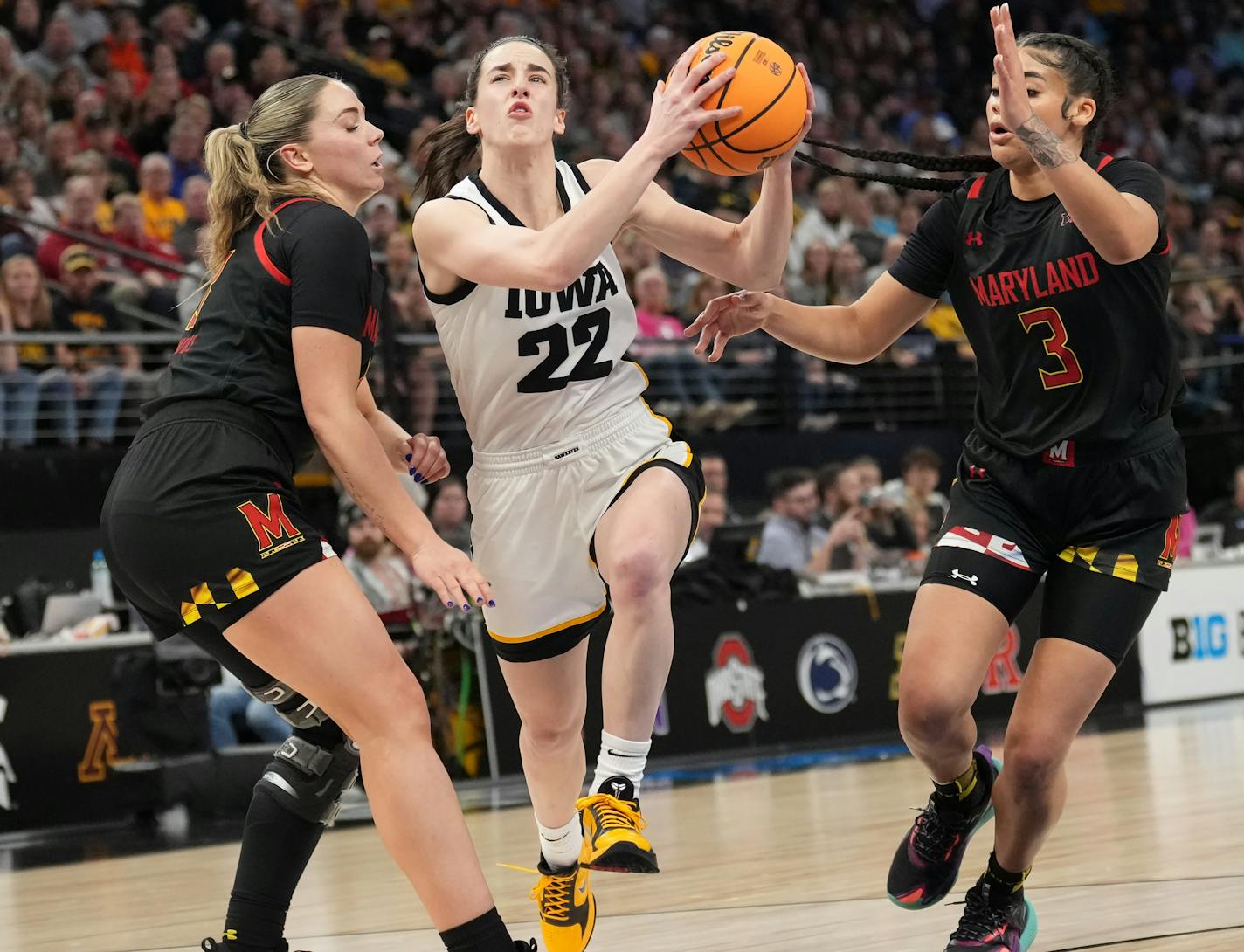 Iowa Hawkeyes guard Caitlin Clark (22) drives to the net through Maryland Terrapins guard Faith Masonius (13) and guard Lavender Briggs (3) in the second quarter of a semifinal matchup at Target Center in Minneapolis, Minn., on Saturday, March 4, 2023. Iowa defeated Maryland 89-84 to advance to the B1G Ten Championship game. ] SHARI L. GROSS • shari.gross@startribune.com