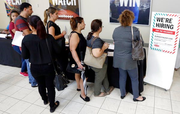 In this Tuesday, Oct. 3, 2017, photo, job seekers wait in line at a job fair at the Dolphin Mall in Sweetwater, Fla. The Labor Department said Thursda