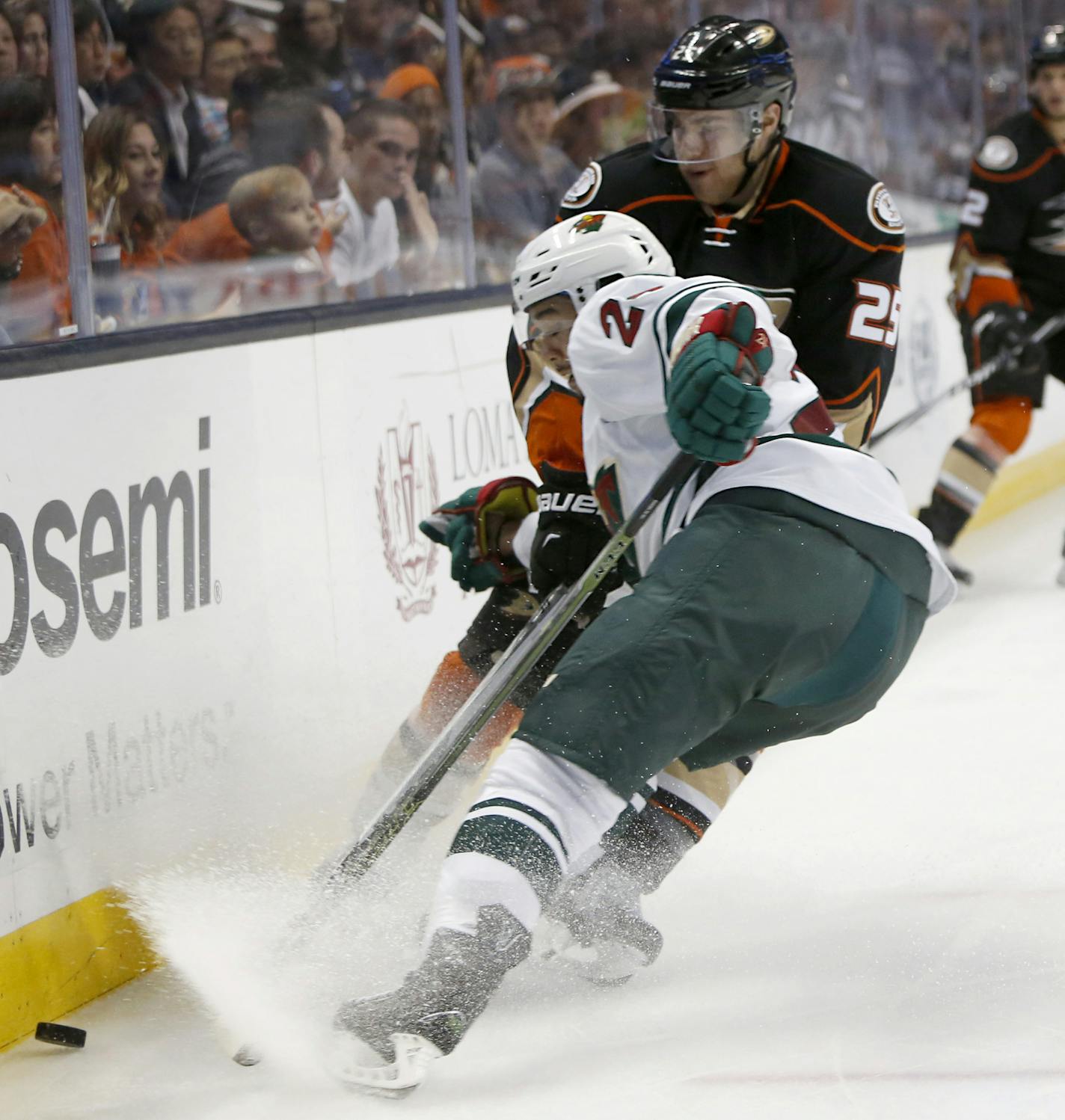 Minnesota Wild's Matt Dumba, front, and Anaheim Ducks' Mike Santorelli fight for possession of the puck in the second period of an NHL hockey game in Anaheim, Calif., Sunday, Oct.18, 2015. (AP Photo/Christine Cotter)