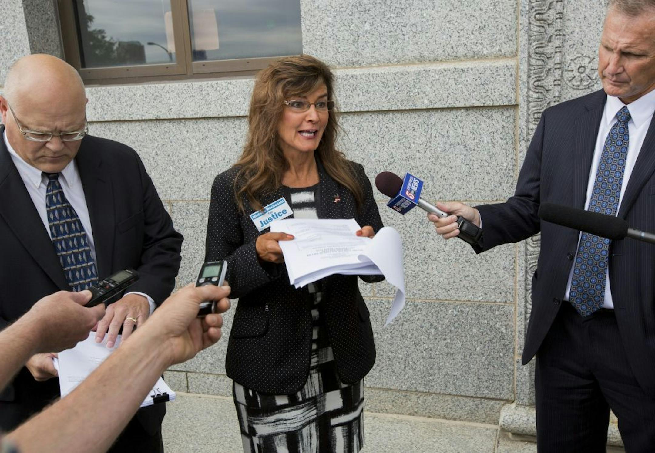 Michelle MacDonald, the Republican Party's endorsed candidate for Minnesota Supreme Court (center), announced a complaint filed against the party, Chairman Keith Downey and others, alleging they attempted to coerce her into giving up her endorsement.