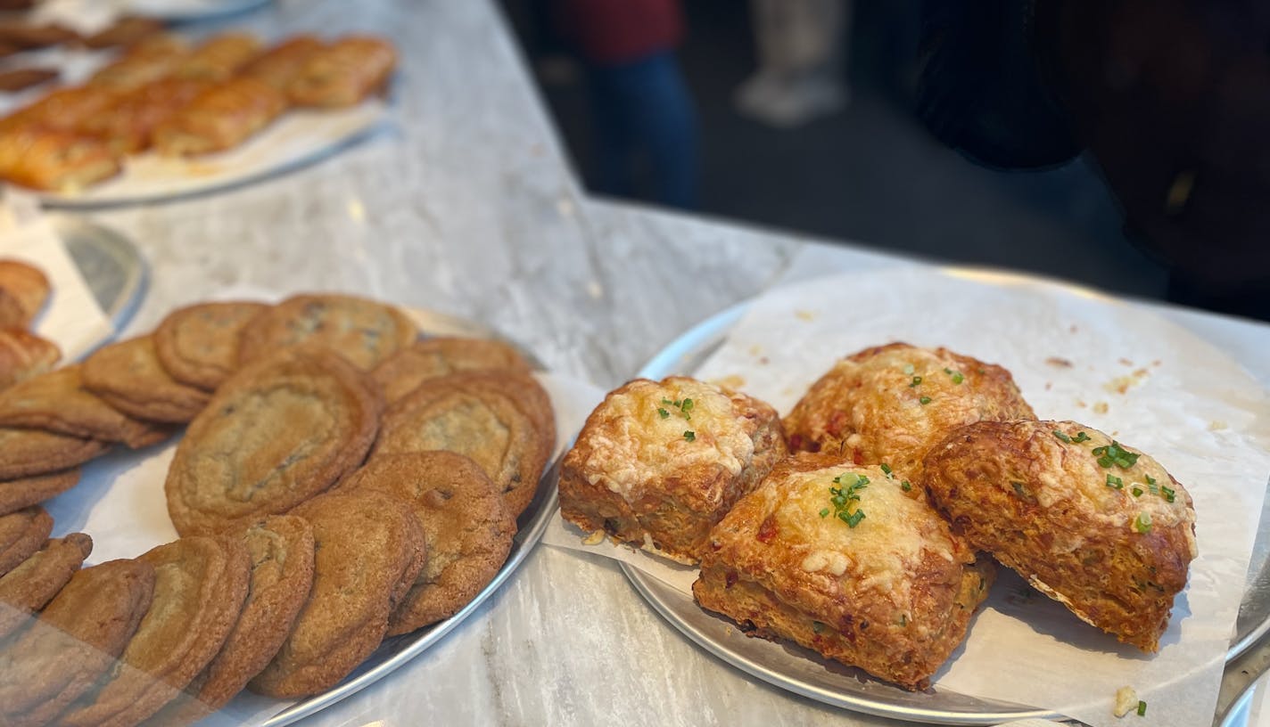 Platters of cheese-topped biscuits, chocolate chip cookies and croissants.