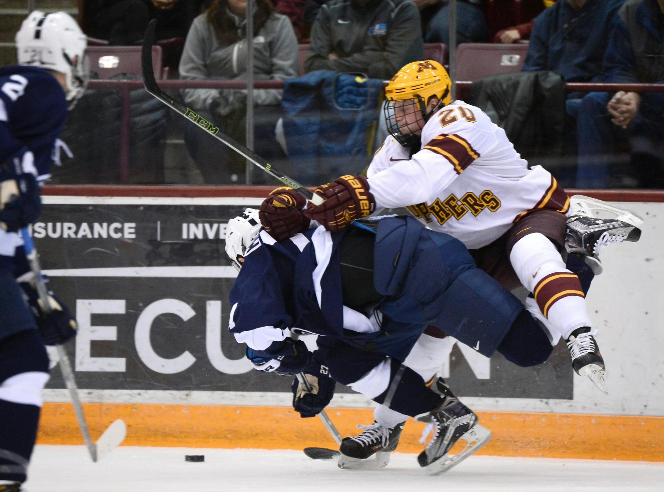 Minnesota Golden Gophers defenseman Michael Brodzinski (20) checked Penn State Nittany Lions forward James Robinson (7) from behind in the third period.