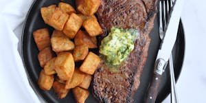 Enjoy a homemade version of Steak Frites with this steak, potatoes, and herb-filled butter.