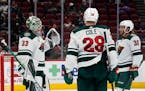 Wild goalie Cam Talbot celebrates a win against the Arizona Coyotes with defenseman Ian Cole (28) and right wing Ryan Hartman (38)