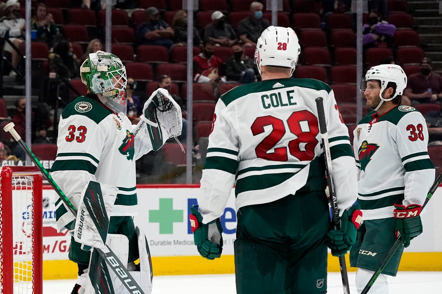 Wild goalie Cam Talbot celebrates a win against the Arizona Coyotes with defenseman Ian Cole (28) and right wing Ryan Hartman (38)