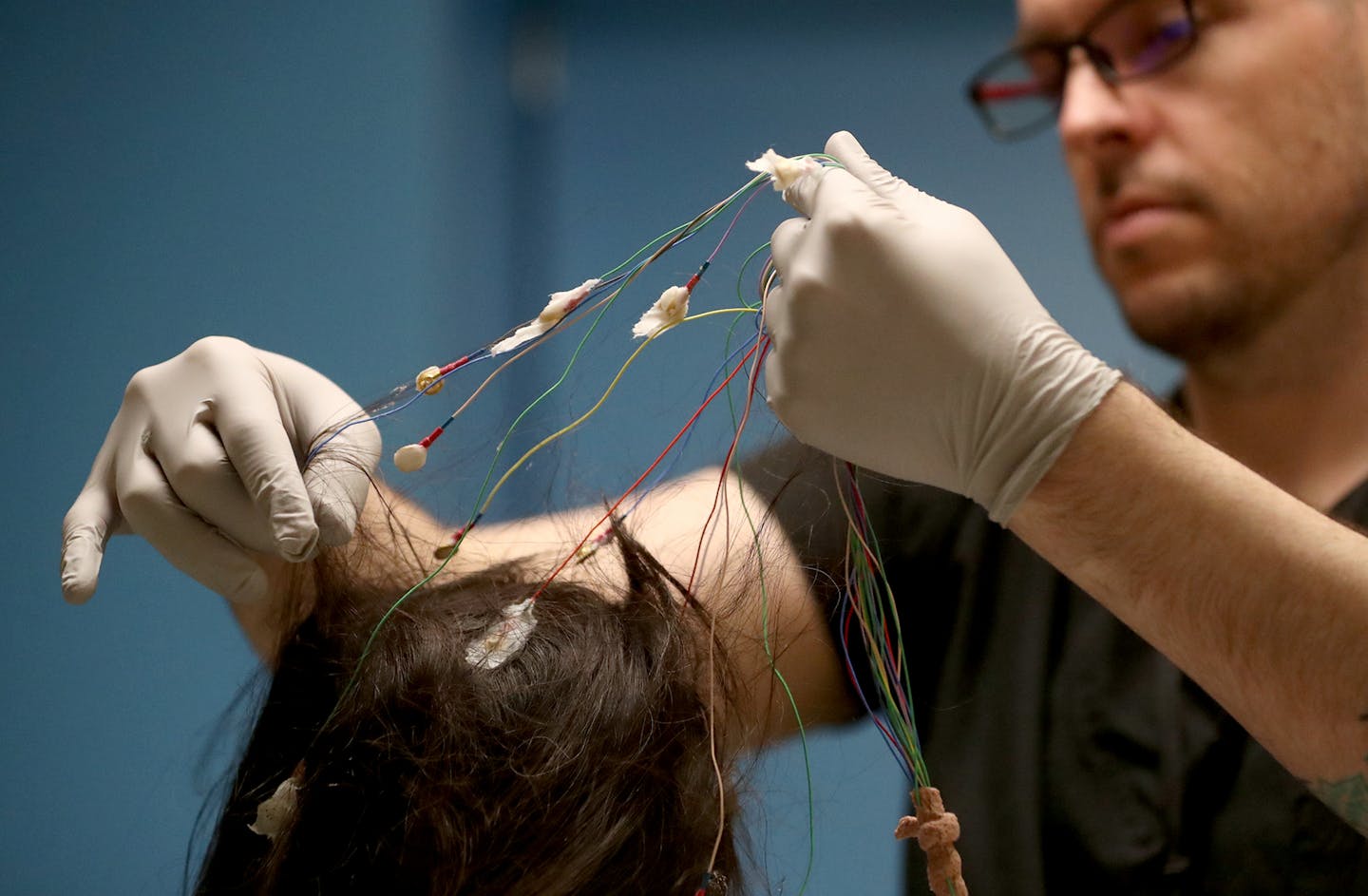 Adam Kornmeyer, an HCMC polysomnographic technologist, removed monitoring equipment from a patient who had just woken up from an all-night sleep test.