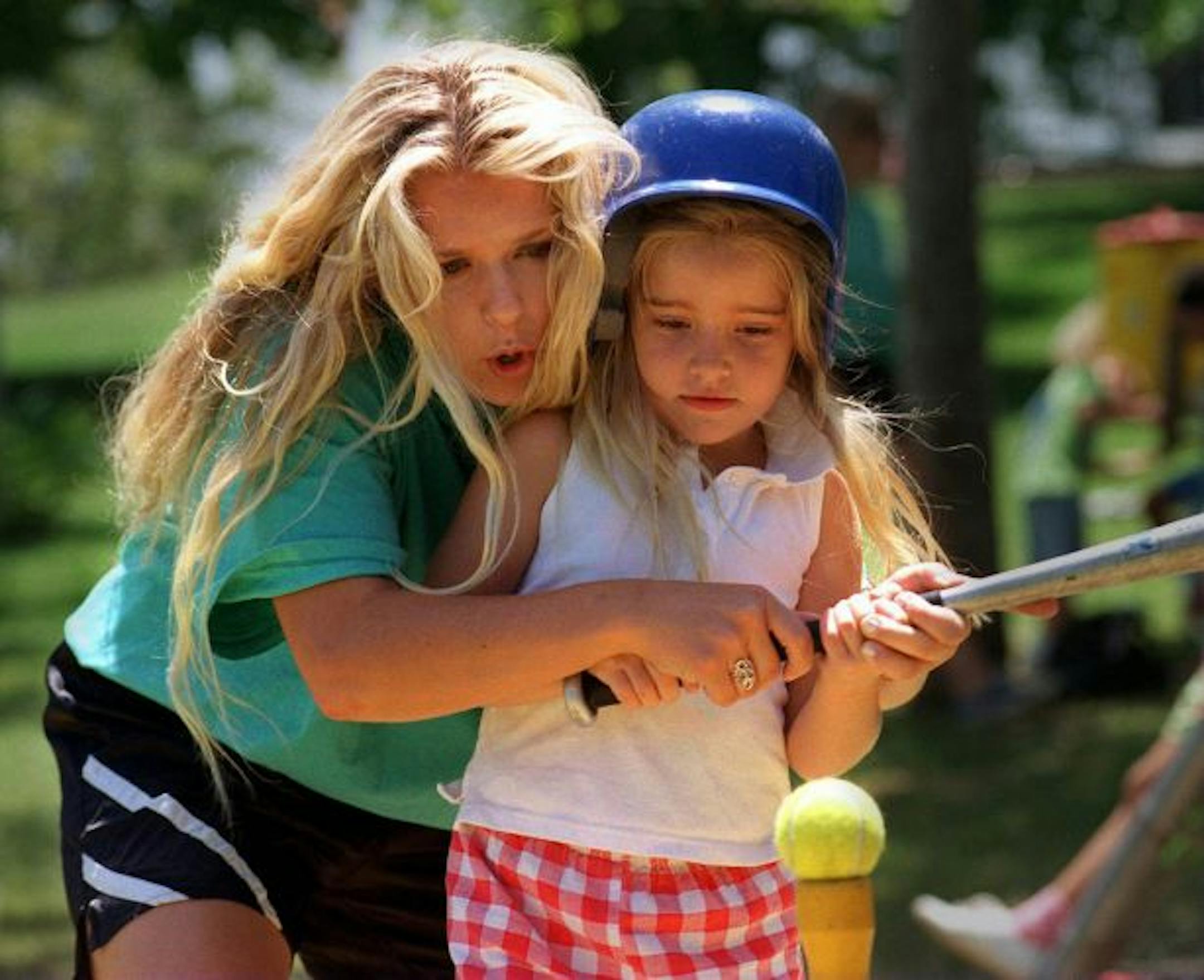 Camp Frasier counselor Becky Burchett gives Samantha Corso, 6, batting pointers at Irvine Regional Park in Irvine, Calif.