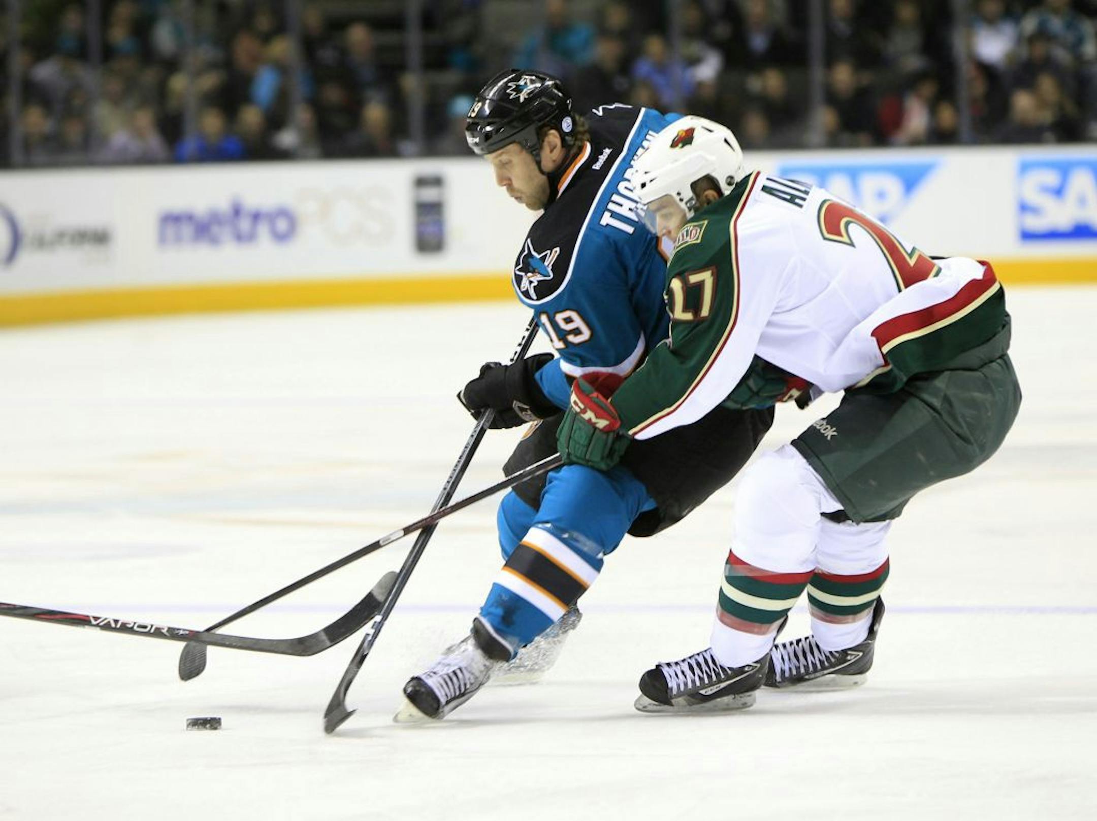 San Jose Sharks' Joe Thornton (19) fights for the puck against Minnesota Wild's Cody Almond (27) in the first period at HP Pavilion in San Jose, California, on Tuesday, Dec. 6, 2011.