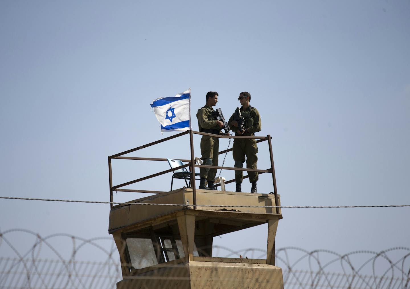 Israeli soldiers guard on top of a watch tower in a community along the Israel- Gaza Strip Border, Tuesday, May 15, 2018. Thousands joined funeral processions Tuesday for some of the dozens of Palestinians killed by Israeli troops in a mass march on the Gaza border, as Israelis faced growing diplomatic fallout from the use of lethal force against unarmed protesters.(AP Photo/Ariel Schalit)